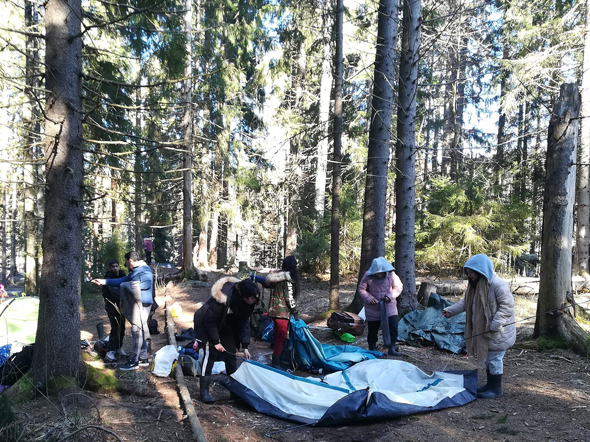 Kerholaiset pysyttävät telttaa metsässä